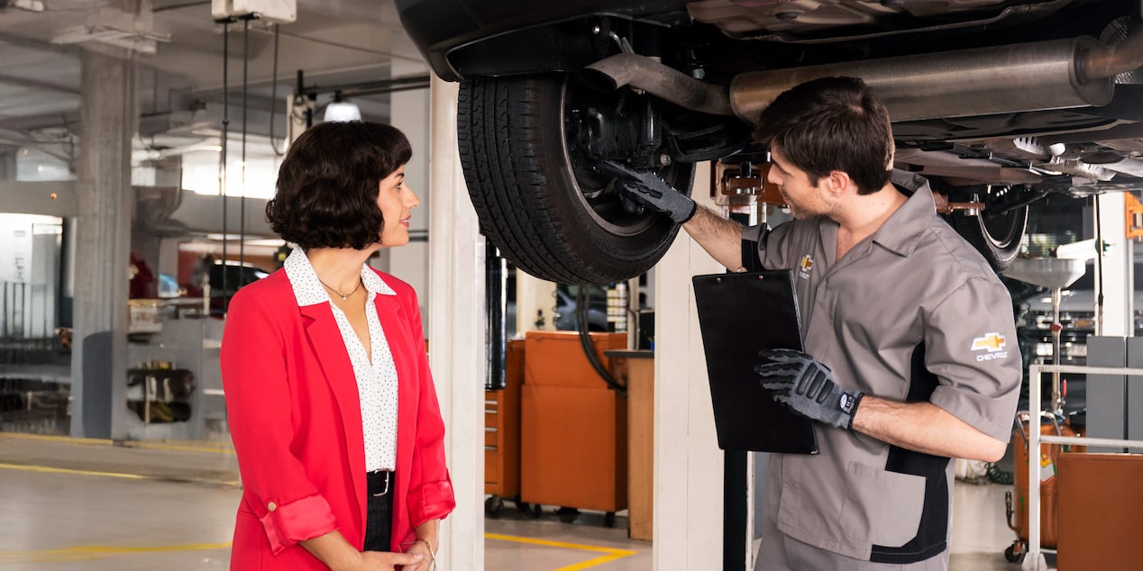 Uno de nuestros especialistas revisando una rueda con una cliente.