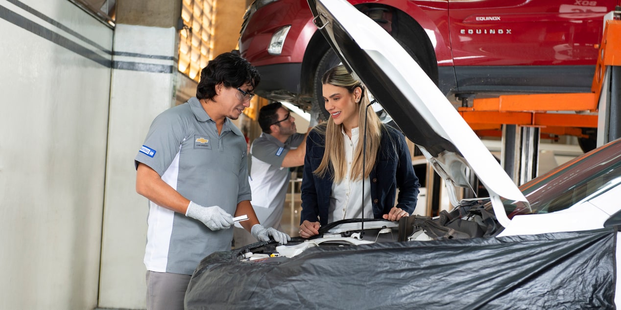 Especialista revisando el motor de una cliente.