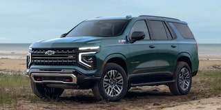 Vista frontal de la Chevrolet Suburban 2025 en color verde sobre terreno de playa, destacando su diseño robusto y tecnología todoterreno Z71