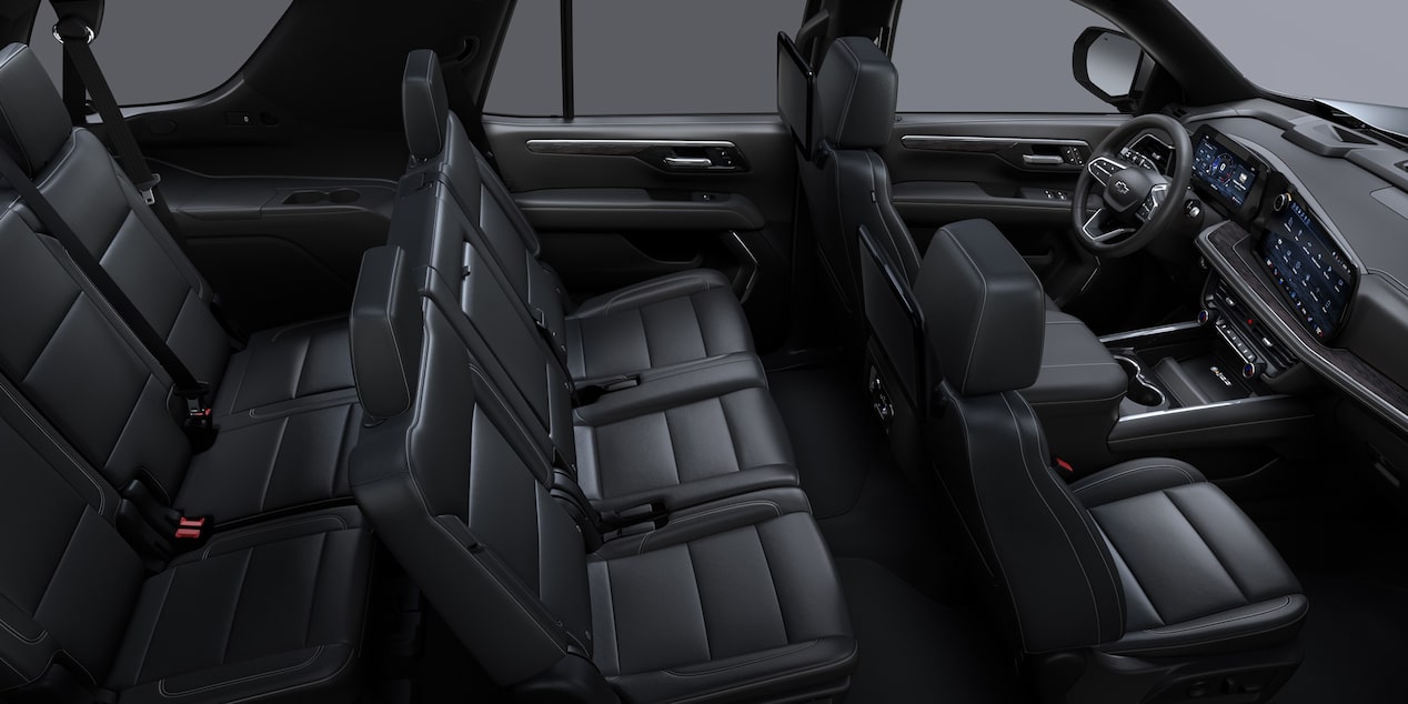 Vista completa del interior de la Chevrolet Suburban con tres filas de asientos en cuero negro y tablero digital