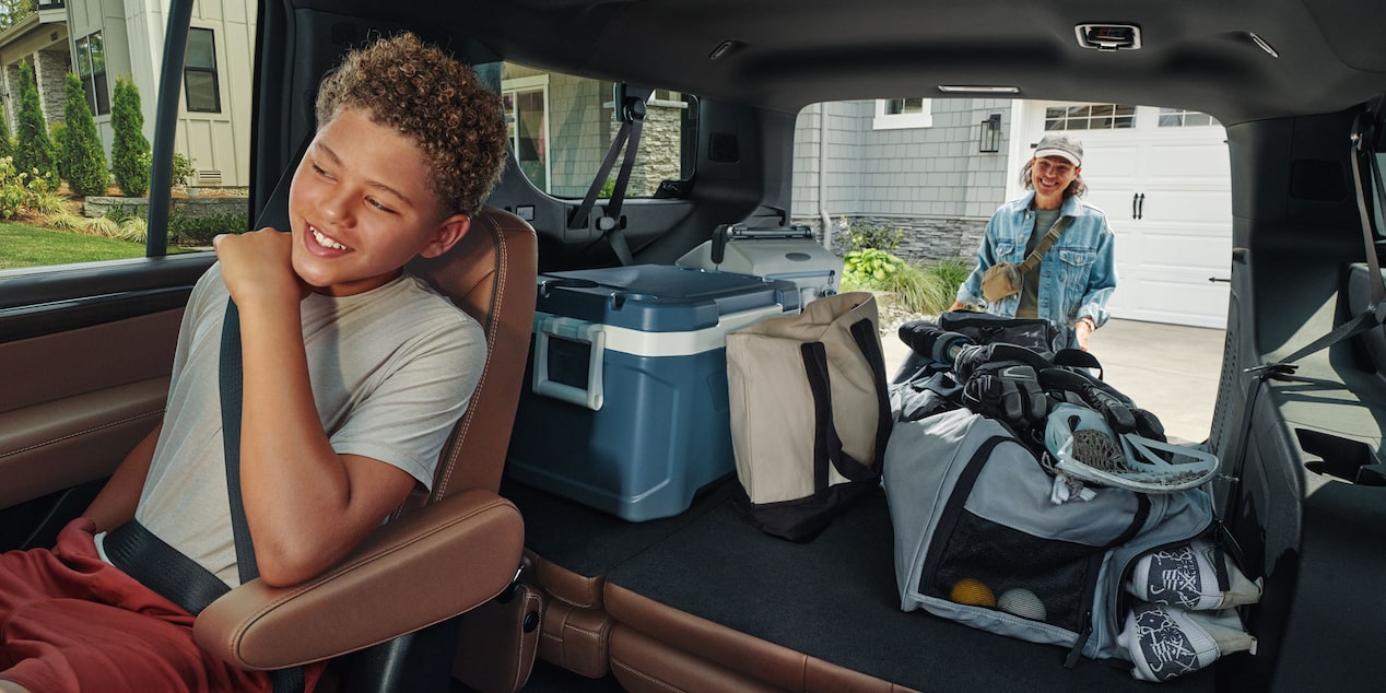 Interior de la Chevrolet Suburban mostrando la tercera fila de asientos con amplio espacio de carga y artículos deportivos