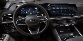 Interior de la Chevrolet Suburban mostrando el volante multifunción y doble pantalla digital de alta tecnología
