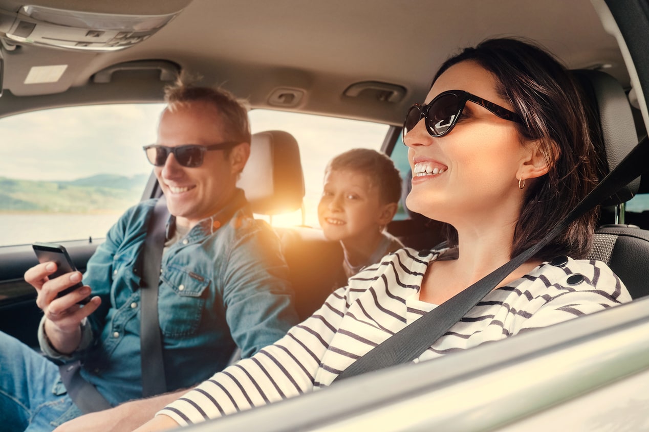 Familia sonriendo durante un viaje en vehículo Chevrolet, disfrutando un trayecto seguro y conectado