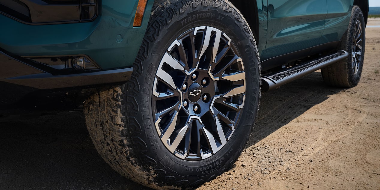 Detalle del rin y llanta todoterreno de la Chevrolet Tahoe 2025 Z71 sobre terreno de tierra