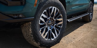 Detalle del rin y llanta todoterreno de la Chevrolet Tahoe 2025 Z71 sobre terreno de tierra