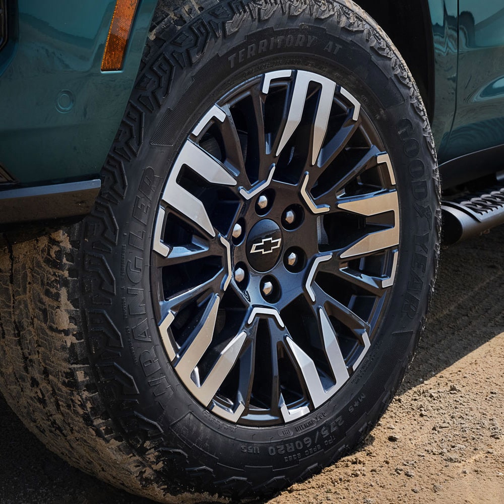 Detalle del rin y llanta todoterreno de la Chevrolet Tahoe 2025 Z71 sobre terreno de tierra