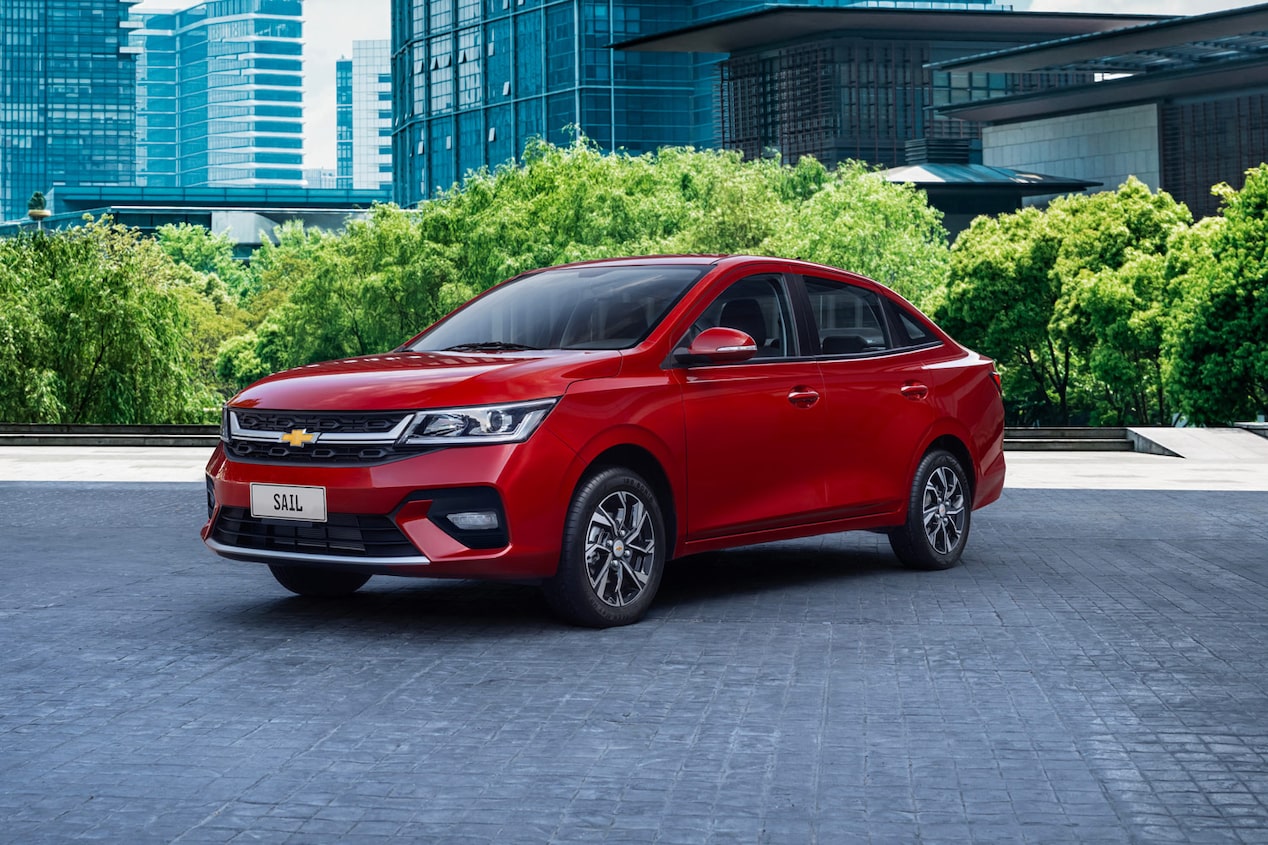  Chevrolet Sail Sedan estacionada en zona urbana, con edificos y árboles detrás.