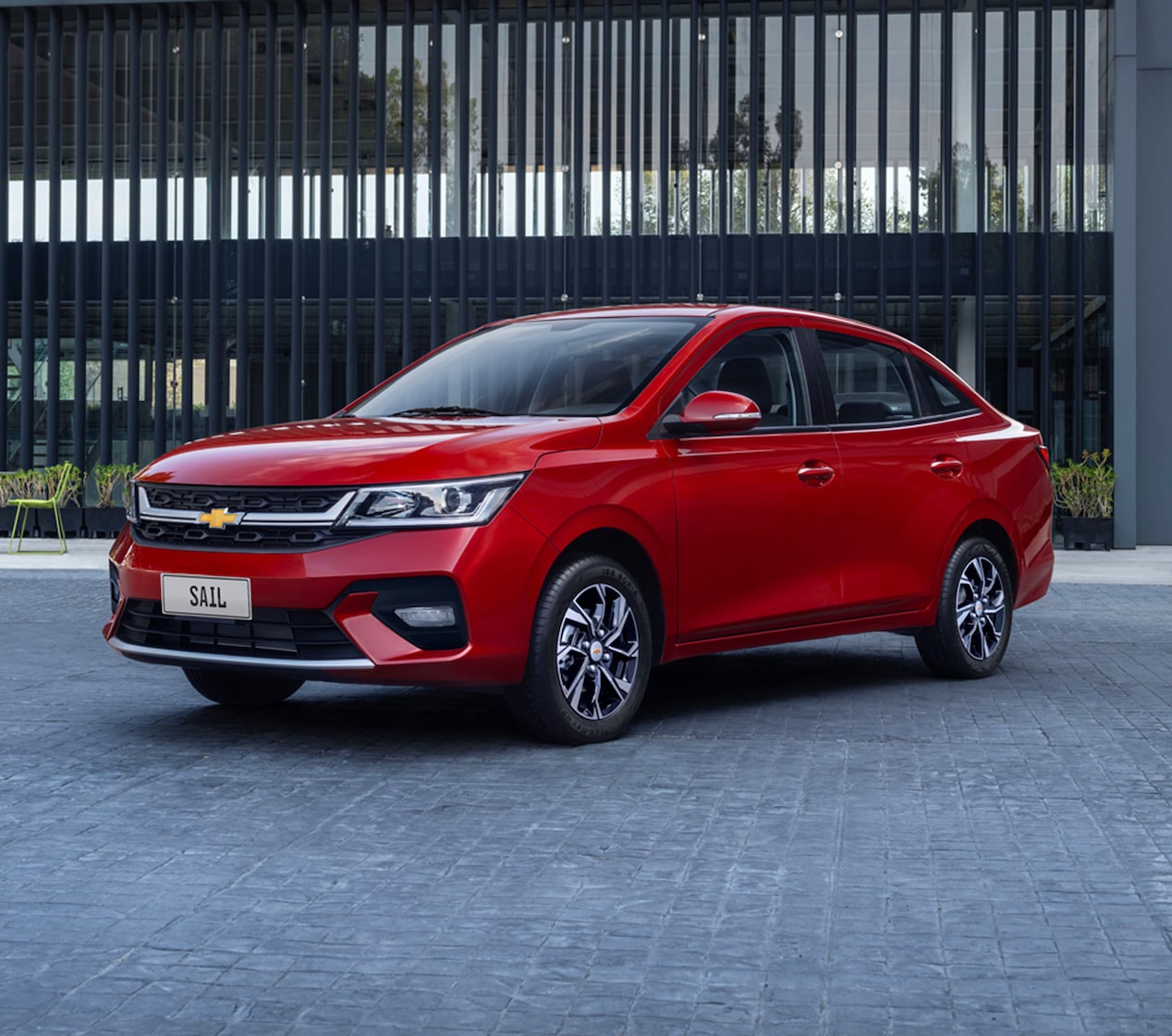 Chevrolet Sail estacionado en la puerta de un edificio.