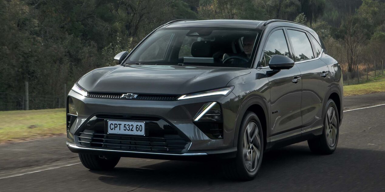 Vista frontal de la Chevrolet Captiva EV circulando por una carretera con vegetación de fondo.