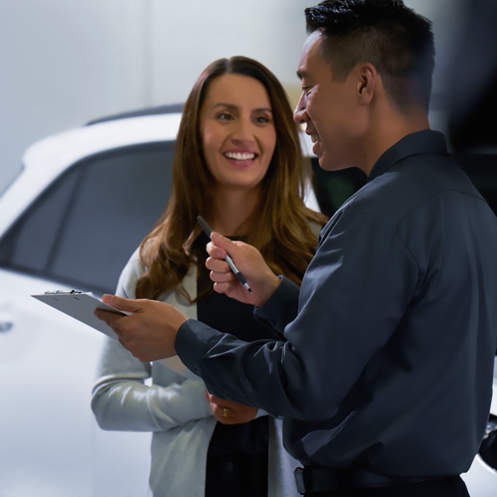 Vendedor de una consesionaria Chevrolet asesorando a una clienta.