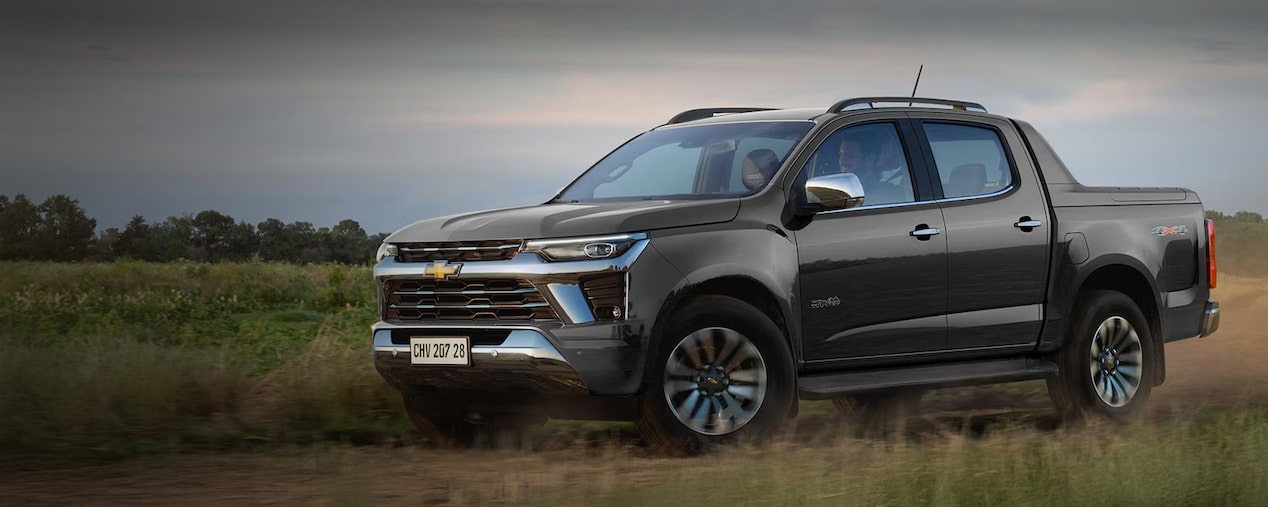 Chevrolet Colorado estacioanada en el campo sobre un pastizal.