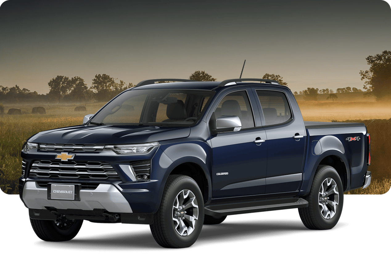 Chevrolet Colorado LTZ en color azul oscuro sobre un fondo campestre con árboles y vacas.