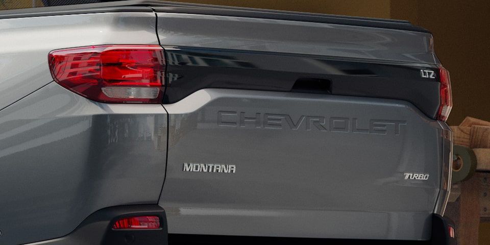 Vista trasera cercana enfocando en el emblema de Chevrolet en la puerta de la caja Multi-Flex de la Montana.