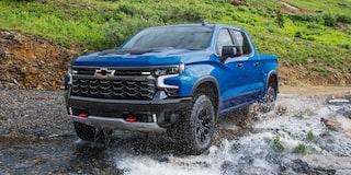 Chevrolet Silverado color azul atravesando un rio.