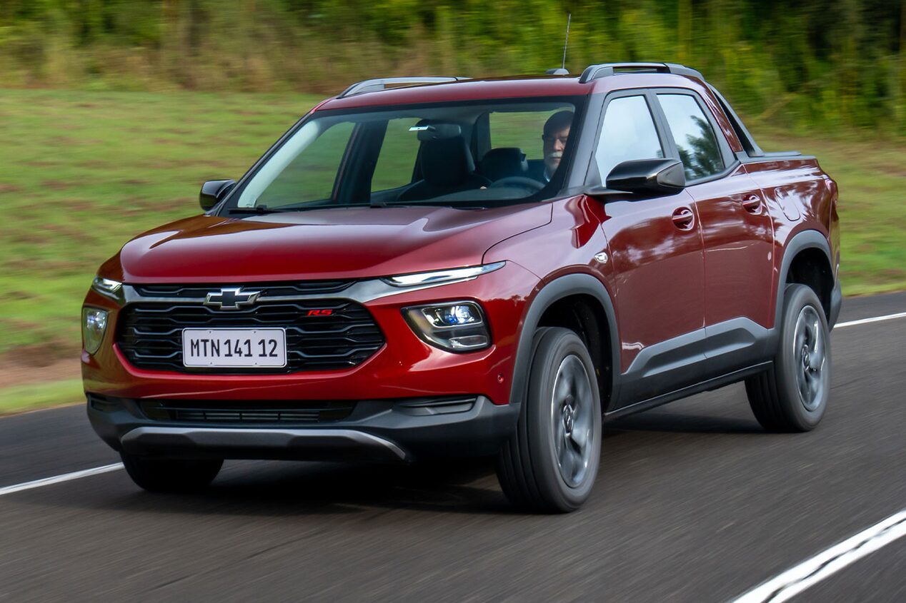 Imagen de una Chevrolet Montana circulando en carretera, con árboles al fondo.