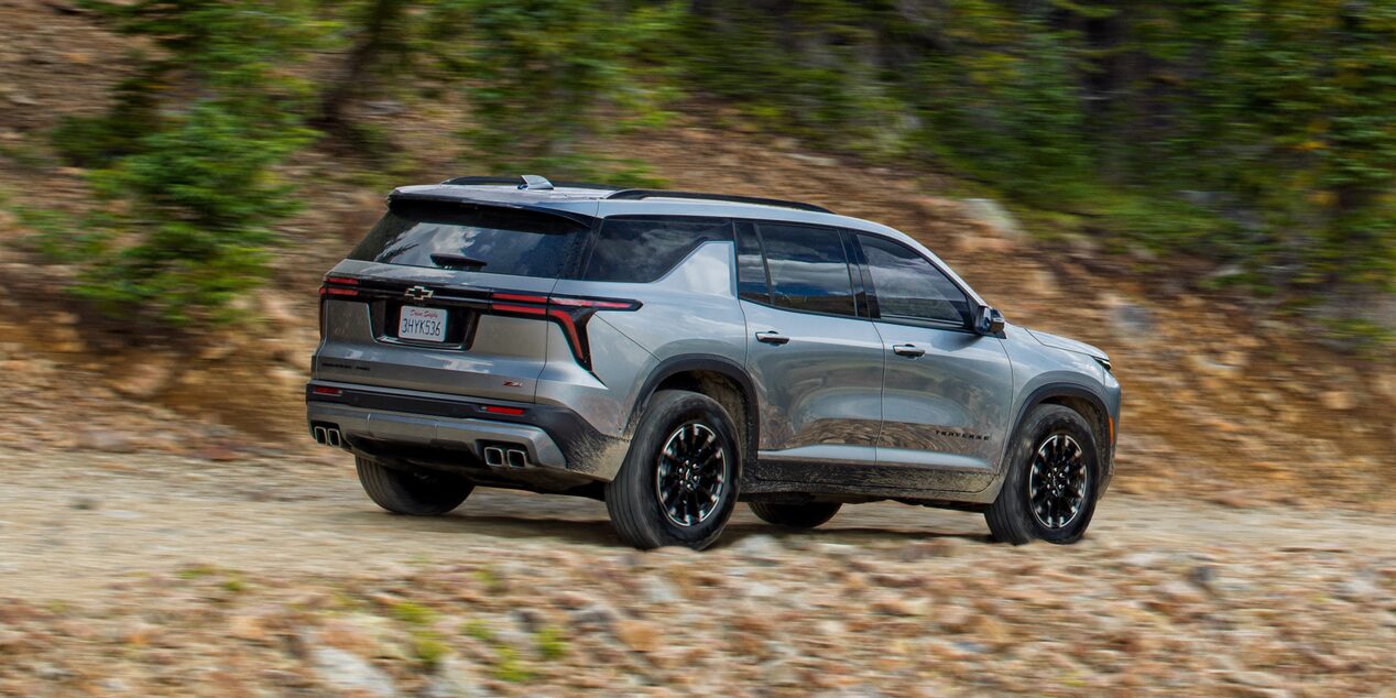 Vista trasera Chevrolet Traverse andando en camino de piedra.